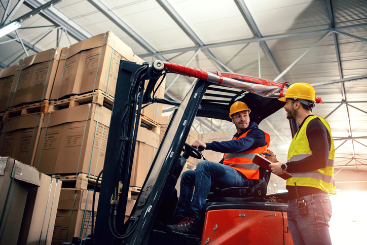 Workers in warehouse with forklift